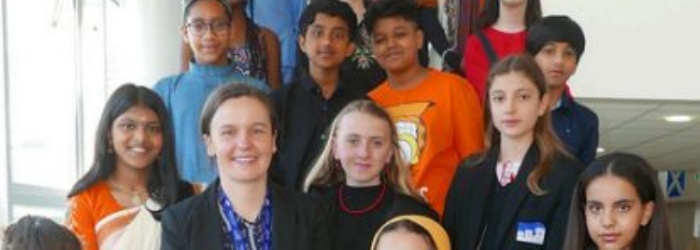 Students from St James stood on stairs wearing traditional or cultural dress